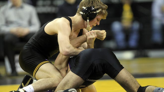 Iowa’s Cory Clark gets ready to turn Northwestern’s Dominic Malone last Friday. Clark pinned Malone in 2:56. He’ll meet Minnesota’s top-ranked Chris Dardanes during a 6 p.m. Friday dual pitting No. 1 Iowa at No. 2 Minnesota in Williams Arena.