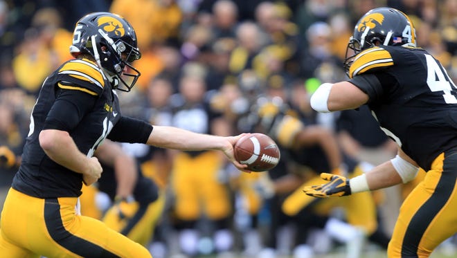 Iowa quarterback Jake Rudock hands the ball to Mark Weisman during their game against Wisconsin at Kinnick Stadium on Saturday, Nov. 22, 2014.