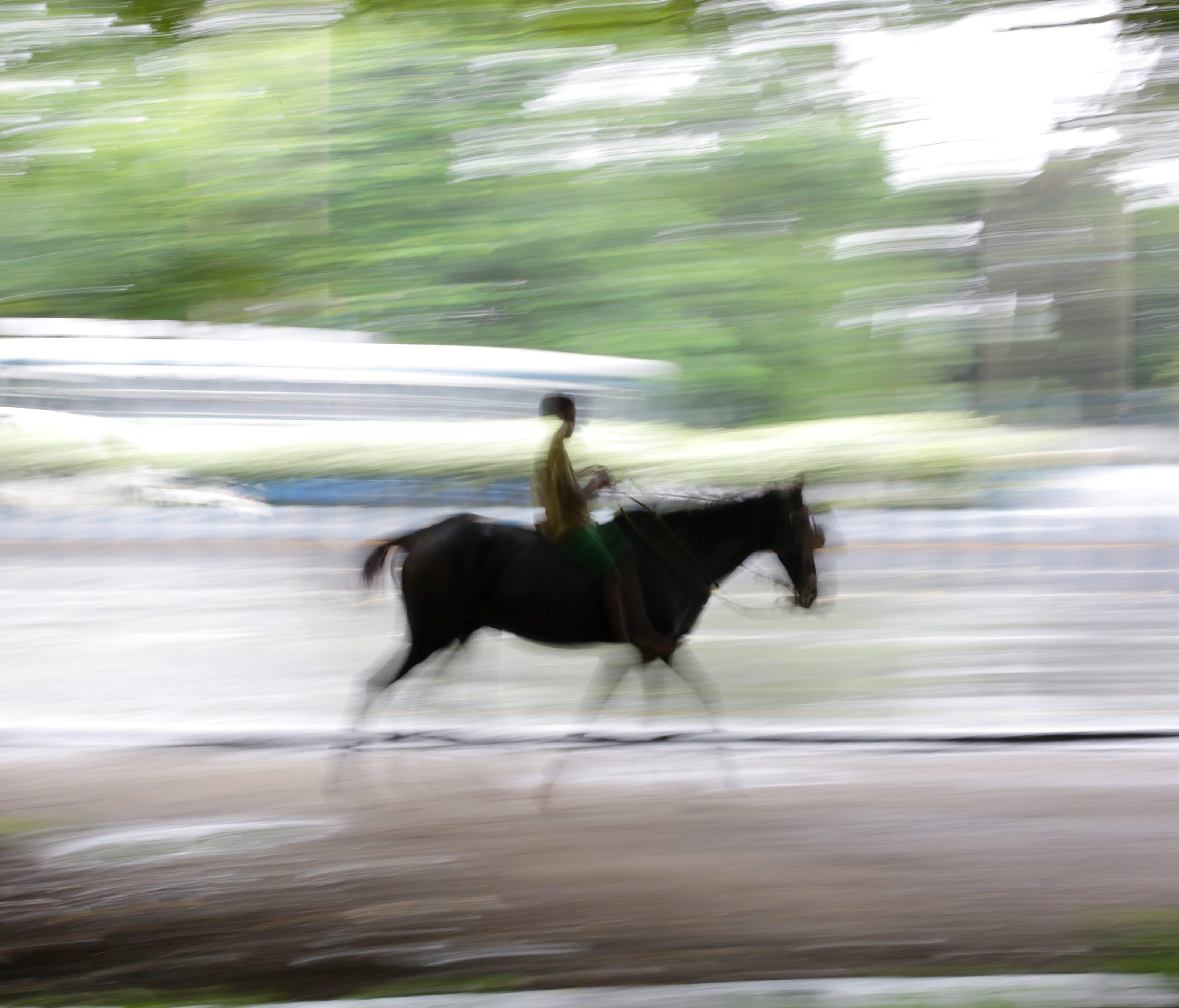 File picture taken with a slow shutter speed shows a boy riding a horse.
