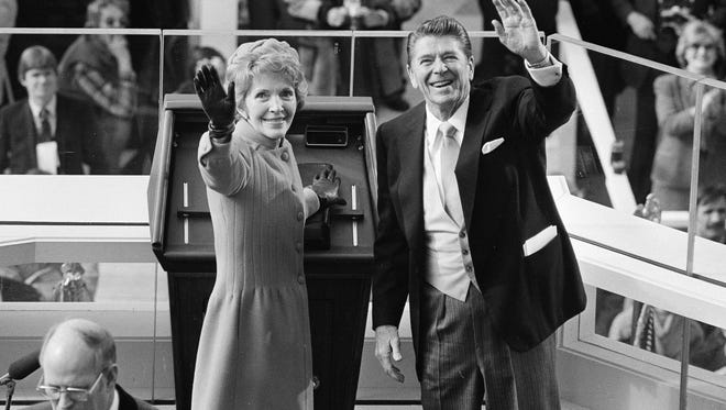 FILE - In this Jan. 20, 1981, file photo, President Ronald Reagan and first lady Nancy Reagan wave to onlookers at the Capitol building as they stand at the podium in Washington following the swearing in ceremony. (AP Photo/File)