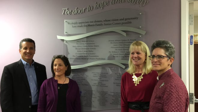 From left, Jim Gerace, Patricia Sly, Judy O'Hagan and Patricia Lee in front of a plaque recognizing donors who raised $1.2 million to support the Morris Family Justice Center, an initiative of the Jersey Battered Women's Service.