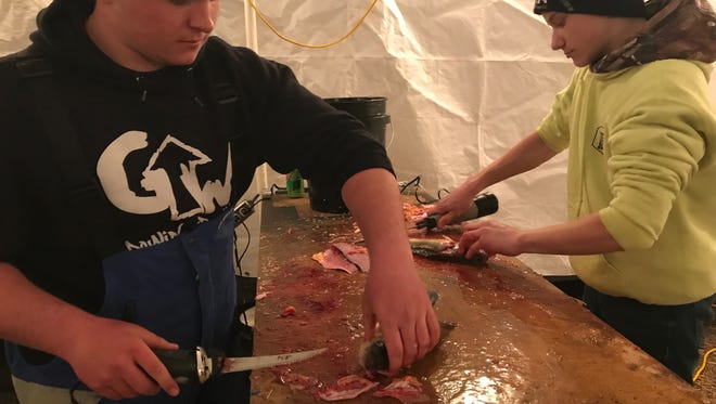 Austin Stankowski and Dawson Rosenthal, both 16, clean fish caught during the Battle on Bago fishing tournament Friday. The cleaned fish are donated to domestic abuse shelters in Oshkosh and Wisconsin Rapids.