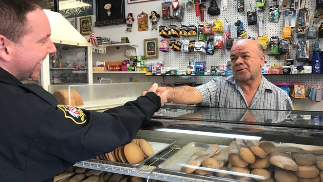 North Plainfield Detective Albert Domizi greets business owner Jario Barrera at his bakery during Domizi's walking patrol on Somerset Street.