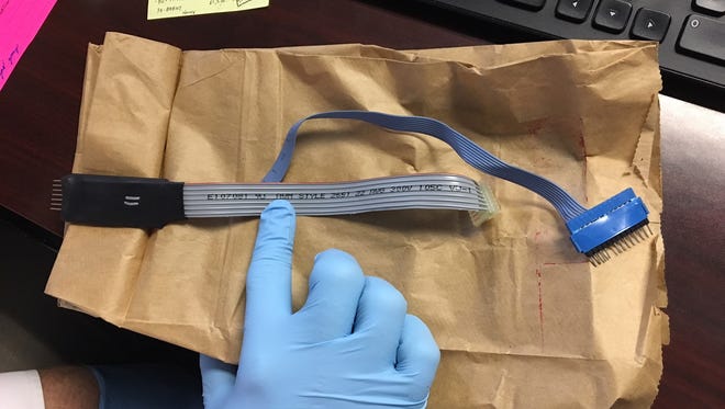 Greenville Police Department Detective Michael Dean shows what a credit card skimming device looks like.