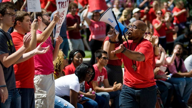 Jonathan Butler uses a megaphone Aug. 26, 2015, to encourage others to stand and chant during a "day of action" celebrating graduate students and draw attention to their demands in Traditions Plaza on the University of Missouri campus in Columbia, Mo.