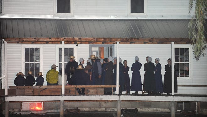Supporters gather on the porch of a house at Route 812 and Mount Alone Road in Heuvelton, N.Y., on Thursday after Fannie Miller, 12, and her sister Delila Miller, 7, were returned home safely after being abducted Wednesday night at a farm stand near their home.