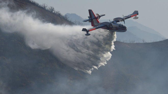 The Canadair CL-415 or Super Scooper makes a drop over Gibraltar Road in Santa Barbara County to help fight the Thomas Fire.