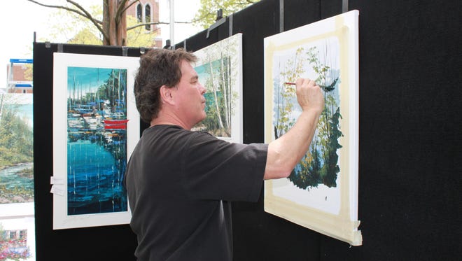 Thomas LeGault of Plymouth works outdoors at an art fair.