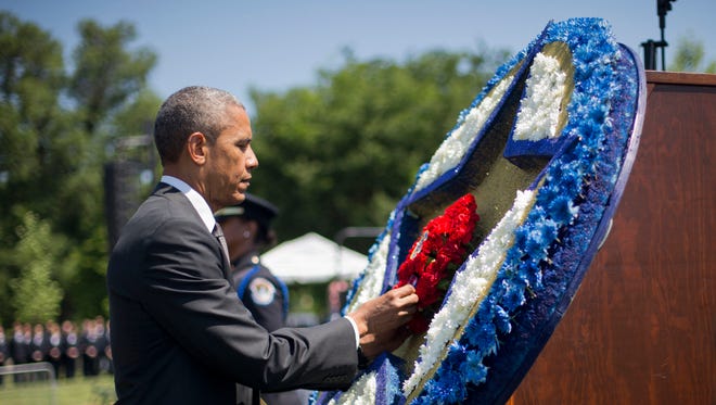 President Barack Obama places a flower on the memorial wreath during the 34th annual National Peace Officers Memorial Service, honoring law enforcement officers who died in the line of duty, on Capitol Hill in Washington on Friday.