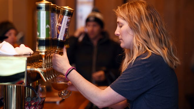 In this Jan. 4, 2018, photo, Erin Krueger pours a pitcher of their Ski Socks American Sour at the Great Northern Brewing Company in Whitefish, Mont. (Brenda Ahearn/The Daily Inter Lake via AP)