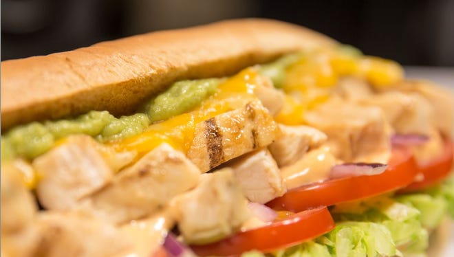 A Subway chicken sandwich with guacamole.