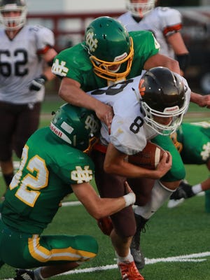 Jud Lewis and Sam Bending tackleHunter Edwards of Nelsonville-York in their first home game of the season.