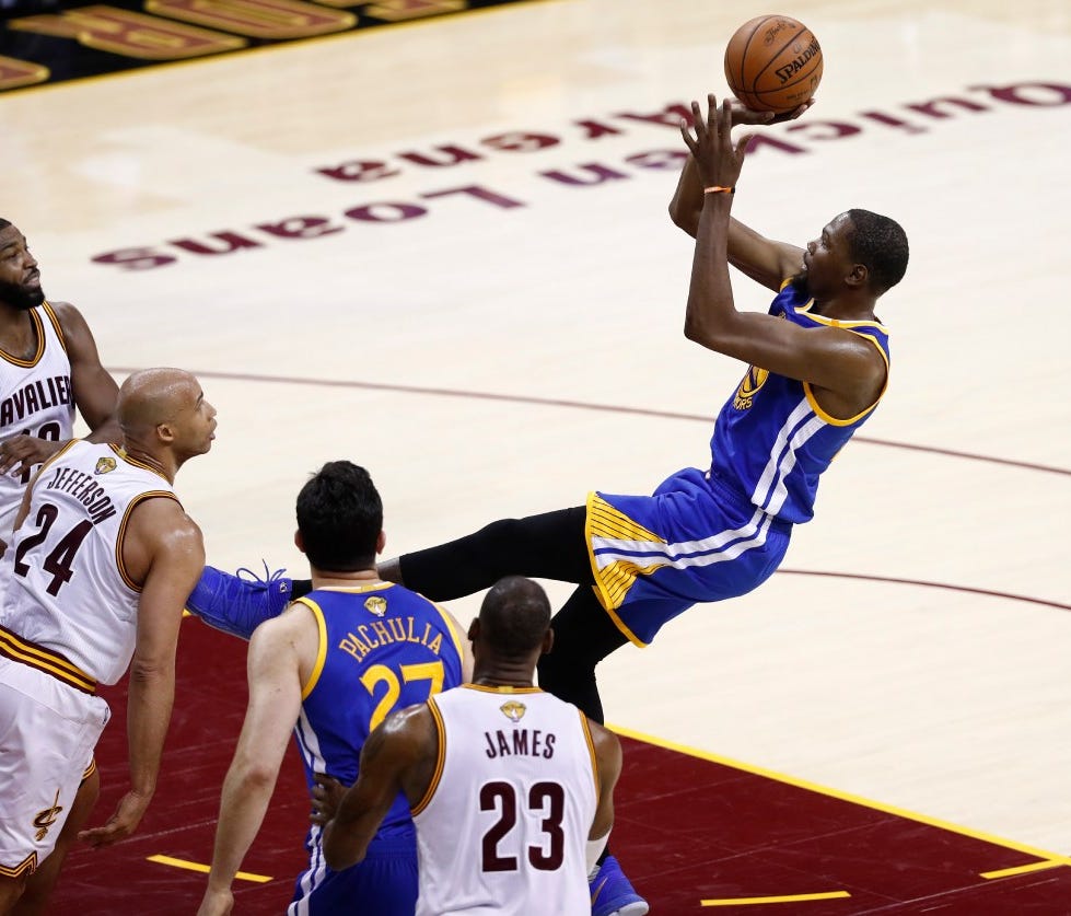 Golden State Warriors forward Kevin Durant (R) takes a shot against the Cleveland Cavaliers in the first half of game three of the NBA Finals basketball game at Quicken Loans Arena in Cleveland, Ohio, USA, June 7, 2017.