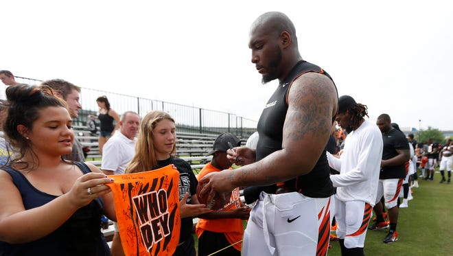 Cincinnati Bengals defensive tackle Devon Still signs autographs for fans after training camp downtown.