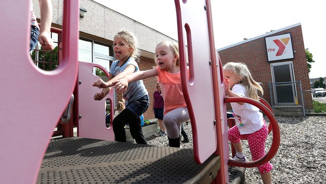 From left, Ava Gehrman, Estelle Torgerson and Alysa Maki play on the playground at the downtown Oshkosh YMCA Thursday. Construction on a 55,000-square-foot facility will begin this summer and is expected to be complete in fall 2017.