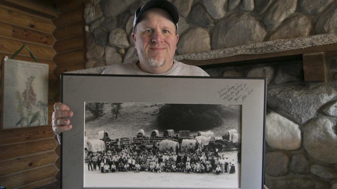In this Monday, Jan. 14, 2019 photo, Kenny Lindsay, owner/auctioneer of Kenny Lindsay's American Eagle Auctions and Appraisals Co., holds an original cast and crew photo from the production of the television show, "Little House on the Prairie," in Genoa Township, Mich. The photo sold for $1200 to the Laura Ingalls Wilder Museum from the estate of Melissa Gilbert and Timothy Busfield.