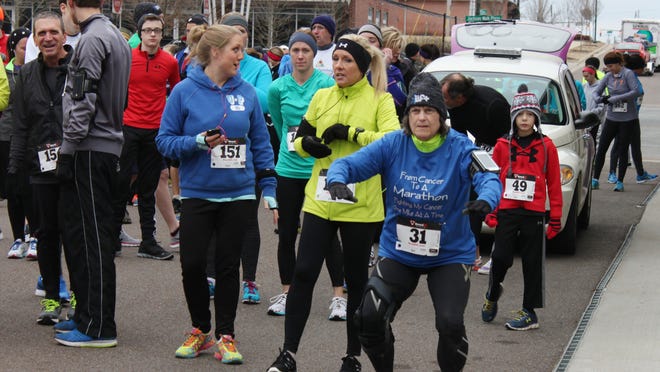 Colleen Johnson (right) stretches before the Commitment Day 5K Run in this Jan. 1, 2015 file photo. The run will be held again this week on New Year's Day.