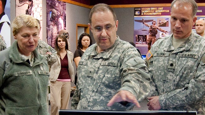 In this March 3, 2011 photo, then-Brig. Gen. Harold Greene, center, speaks beside Gen. Ann Dunwoody, left, during her tour of the Natick Soldier Systems Center in Natick, Mass.