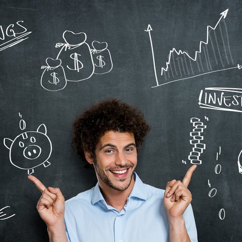 Young man in front of  chalkboard with financial c