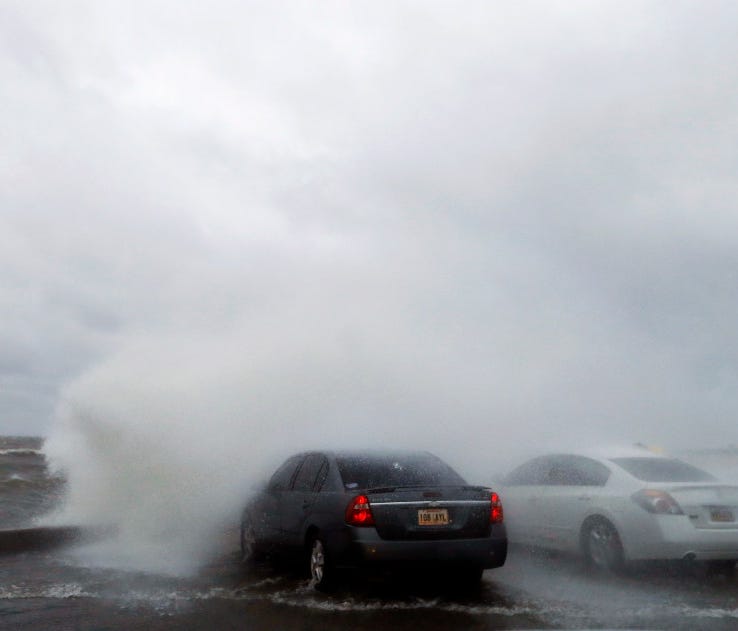 People sit in a car and watch the waves on the shore of Lake Pontchartrain as weather from Tropical Storm Cindy, in the Gulf of Mexico, impacts the region in New Orleans, Tuesday.