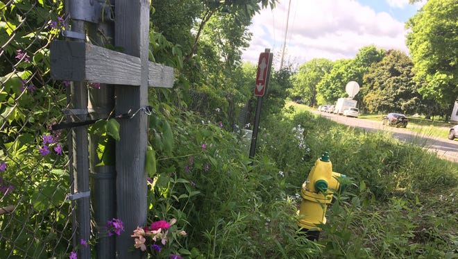 A makeshift memorial shown on June 8, 2016, with a cross and flower bouquet left where five bicyclists were killed and four injured.