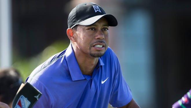 Tiger Woods holds himself up on the first tee during the third round of the Hero World Challenge golf tournament on Saturday, Dec. 6, 2014, in Windermere, Fla. Woods lost his voice overnight and was nauseated before and during the third round at Isleworth. (AP Photo/Willie J. Allen Jr.) ORG XMIT: FLWA106