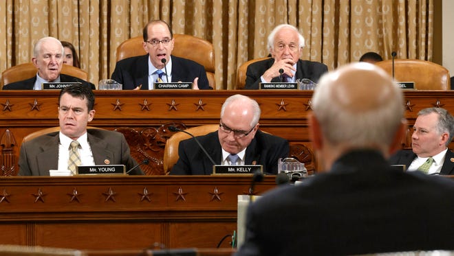 House Ways and Means Committee Chairman Rep. Dave Camp , R-Mich., center, flanked by the committee's ranking member Rep. Sander Levin, D-Mich., right, and Rep. Sam Johnson, R-Texas, questions Internal Revenue Service (IRS) Commissioner John Koskinen as he appears before the committee on Capitol Hill in Washington, Friday, June 20, 2014, in their continuing probe of whether tea party groups were improperly targeted for increased scrutiny by the IRS. The IRS asserts it can't produce emails from seven officials connected to the tea party investigation because of computer crashes, including the emails from Lois Lerner, the former IRS official at the center of the investigation who has invoked her Fifth Amendment right at least nine times to avoid answering lawmakers' questions.