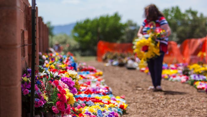 Jill Smith looks for flowers that were on the graves of her mother and son at the Cedar City Cemetery, Wednesday, June 8, 2016.