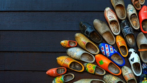 Colorful wooden clogs on dark wooden panels