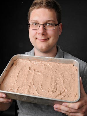 Paul Fenlason holds a cake he developed as a North Dakota State University cereal science graduate student. The cake is lower in calories and promotes the growth of beneficial micro-organisms in the large intestine.