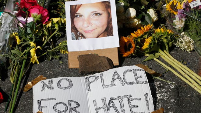 A makeshift memorial of flowers and a photo of victim, Heather Heyer, sits in Charlottesville, Va., Sunday, Aug. 13, 2017. Heyer died when a car rammed into a group of people who were protesting the presence of white supremacists who had gathered in the city for a rally. 