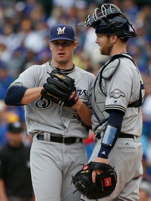 Brewers starting pitcher Chase Anderson (left) listens to catcher Jett Bandy in the first inning Sunday.
