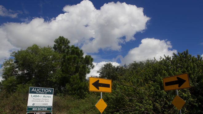 A sign advertises the auction of 1,400+ acres near the intersection of Jacaranda Parkway and Chiquita Boulevard in Northern Cape Coral Wednesday.