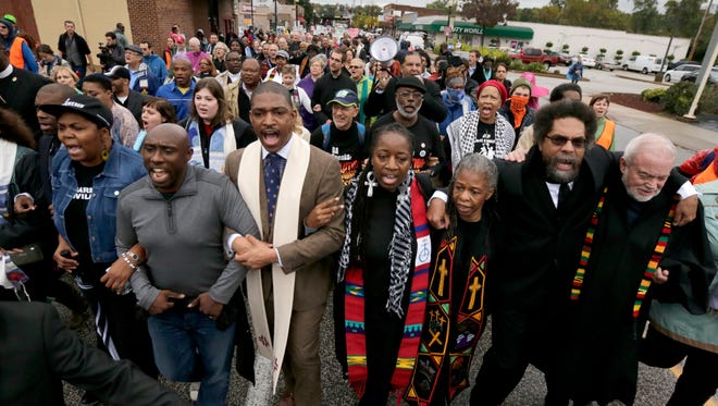 Protesters, including Cornel West, second from right, march to the Ferguson, Mo., police station, Monday, Oct. 13, 2014, in Ferguson. Activists planned a day of civil disobedience to protest the shooting of Michael Brown, in August, and a second police shooting in St. Louis last week. (AP Photo/Charles Rex Arbogast)
