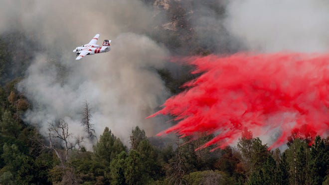 In this file photo, an air tanker drops retardant while fighting to stop the Ferguson Fire from reaching homes in the Darrah community in Mariposa County.