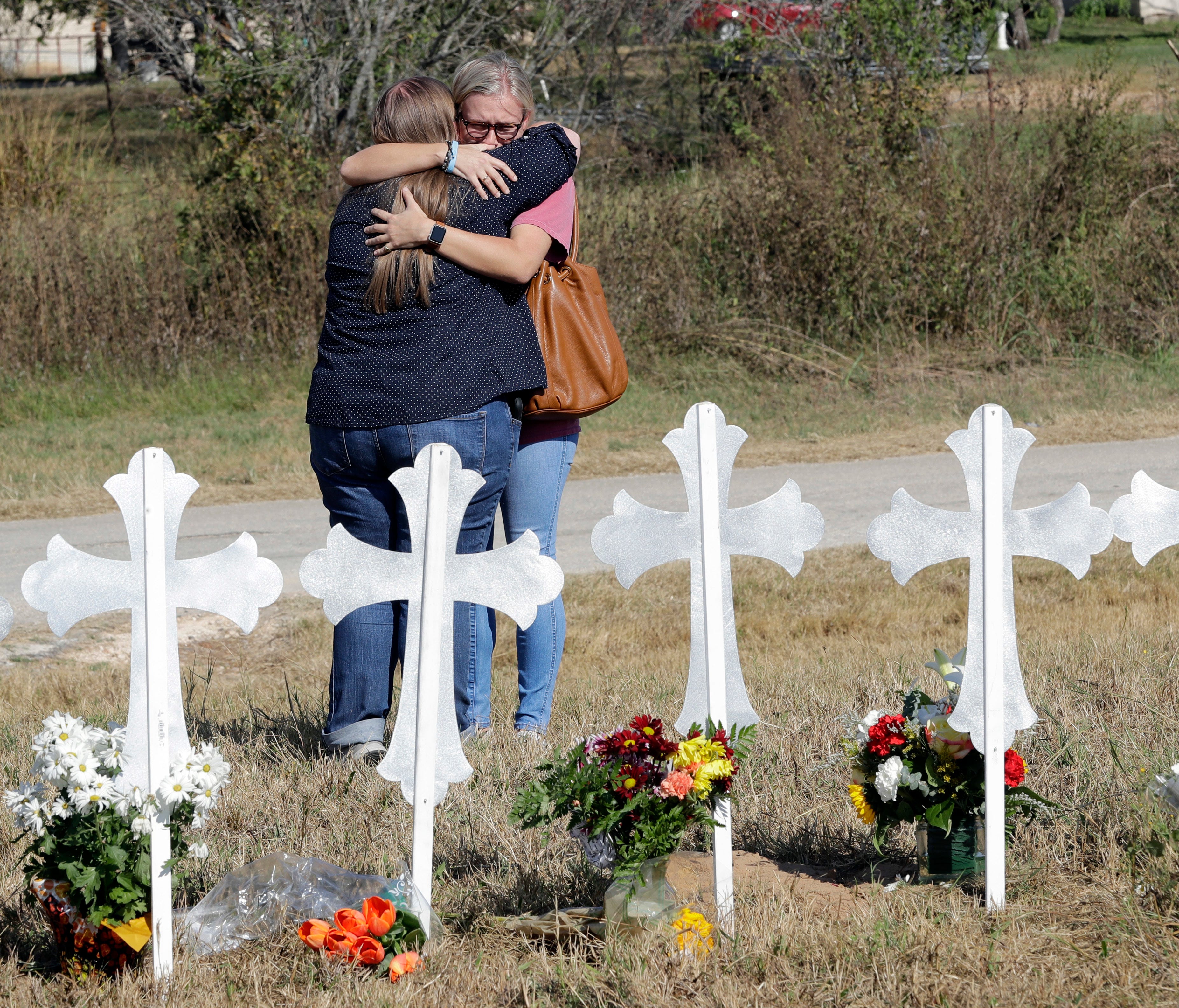 Two women hug at a makeshift memorial for the First Baptist Church shooting victims  in Sutherland Springs, TX, Nov. 7, 2017.  A man opened fire inside the church in the small South Texas community on Sunday, killing more than two dozen and injuring 