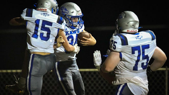 Reichen Rush (34) celebrates with Perry-Lecompton teammates Hunter Hess (15) and Sean Urban (75) after scoring the go-ahead touchdown on a 30-yard run in the Kaws' 28-14 win at Holton on Friday.