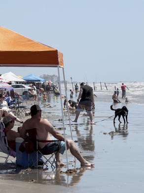 Beachgoers line the water’s edge at Hershey Beach in Galveston, Texas, on Saturday. People flocked to the island’s beaches that reopened Friday after being closed in response to the COVID-19 pandemic.