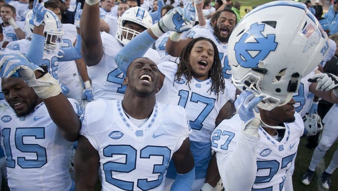 North Carolina's Cayson Collins (23) and his teammates celebrate a 30-27 overtime victory against Virginia Tech on Saturday, Nov. 21, 2015, at Lane Stadium in Blacksburg, Va. UNC won, 30-27, in overtime.