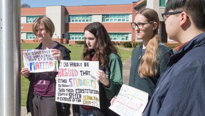 Freshmen Annie Pratt, left to right, Gabrielle Vines, Caitlin Sarfert, and junior Liam Chau joined the National Walkout to show their support for the Parkland victims instead of attending an assembly at Pensacola High School on Wednesday, March 14, 2018.