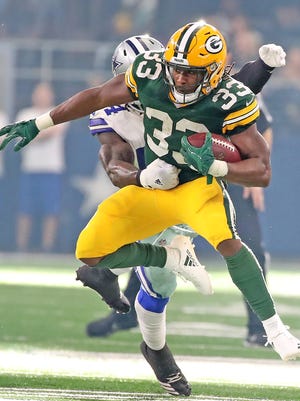 Green Bay Packers running back Aaron Jones (33) jumps through a hole in the defense against the Dallas Cowboys Sunday, October 8, 2017 at AT&T Stadium in Arlington, Tx.