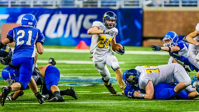 Jared Smith, center, of Pewamo-Westphalia cuts back to a hole in the Ishpeming line late in the 4th quarter of the Division 7 state high school football title game.  He ended the season with 3,250 rushing yards, a new state record.