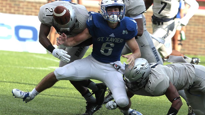 Louis Raines of St. Xavier can only watch the ball as it pops out of his grasp.  St. John Bosco recovered the fumble and went on to score on the drive.  St. Xavier took on St. John Bosco out of California as part of the Skyline Crosstown Showdown at Nippert Stadium Saturday, August 27, 2016.