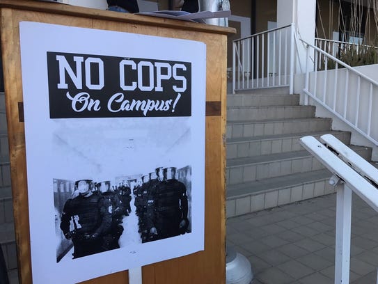 A "No Cops on Campus" sign on the podium where students