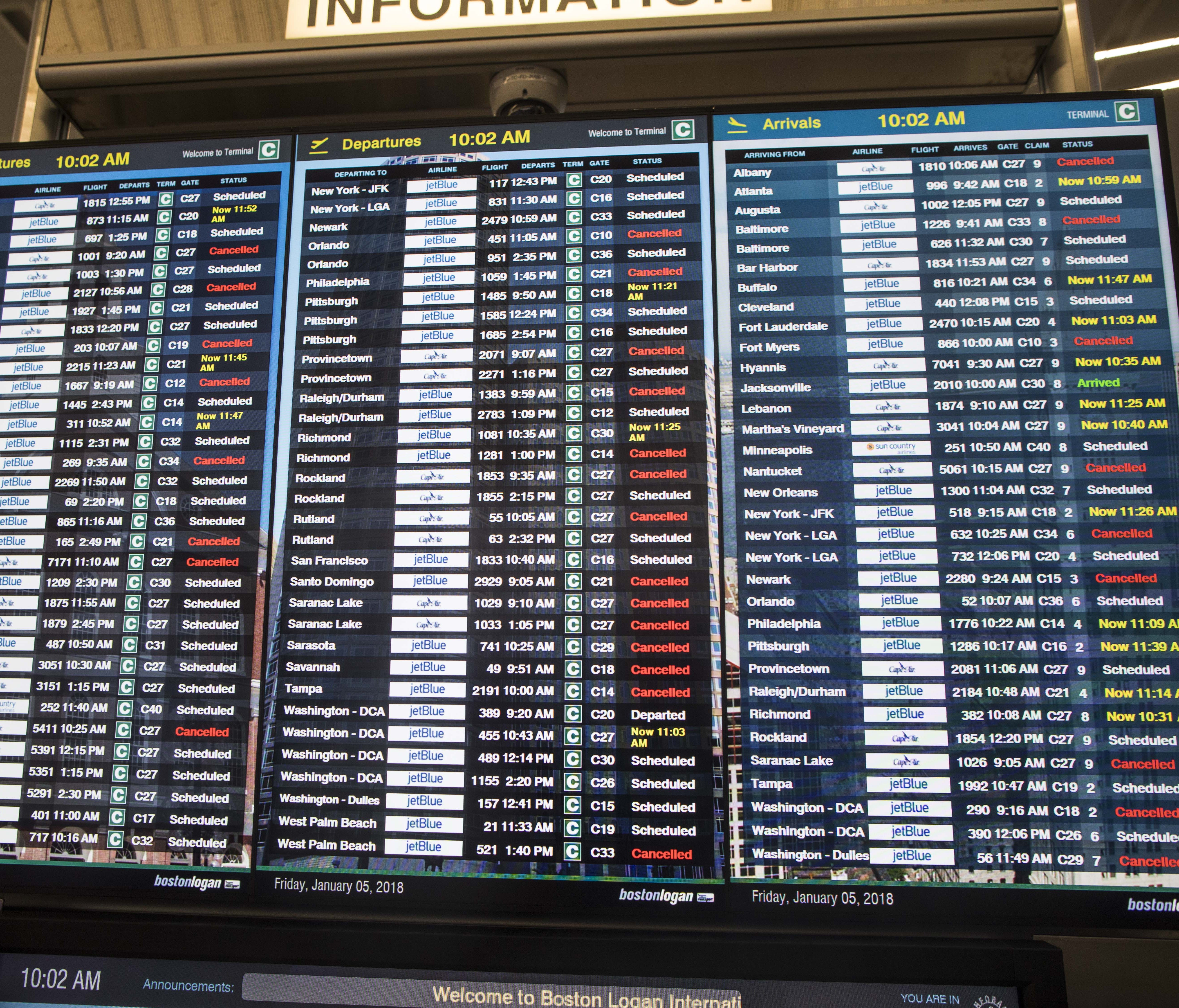 This file photo from Jan. 5, 2018, shows many delays and cancellations on a flight display board at Boston's Logan International Airport amid an earlier snow storm.