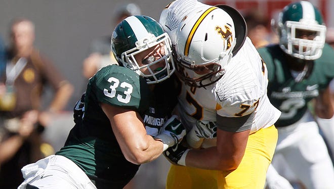 Michigan State linebacker Jon Reschke is blocked by Wyoming offensive tackle Connor Rains during the first half Saturday in East Lansing.