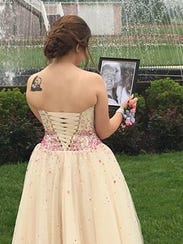 Kaylee Suders looks at a photo of her and Carter Brown,