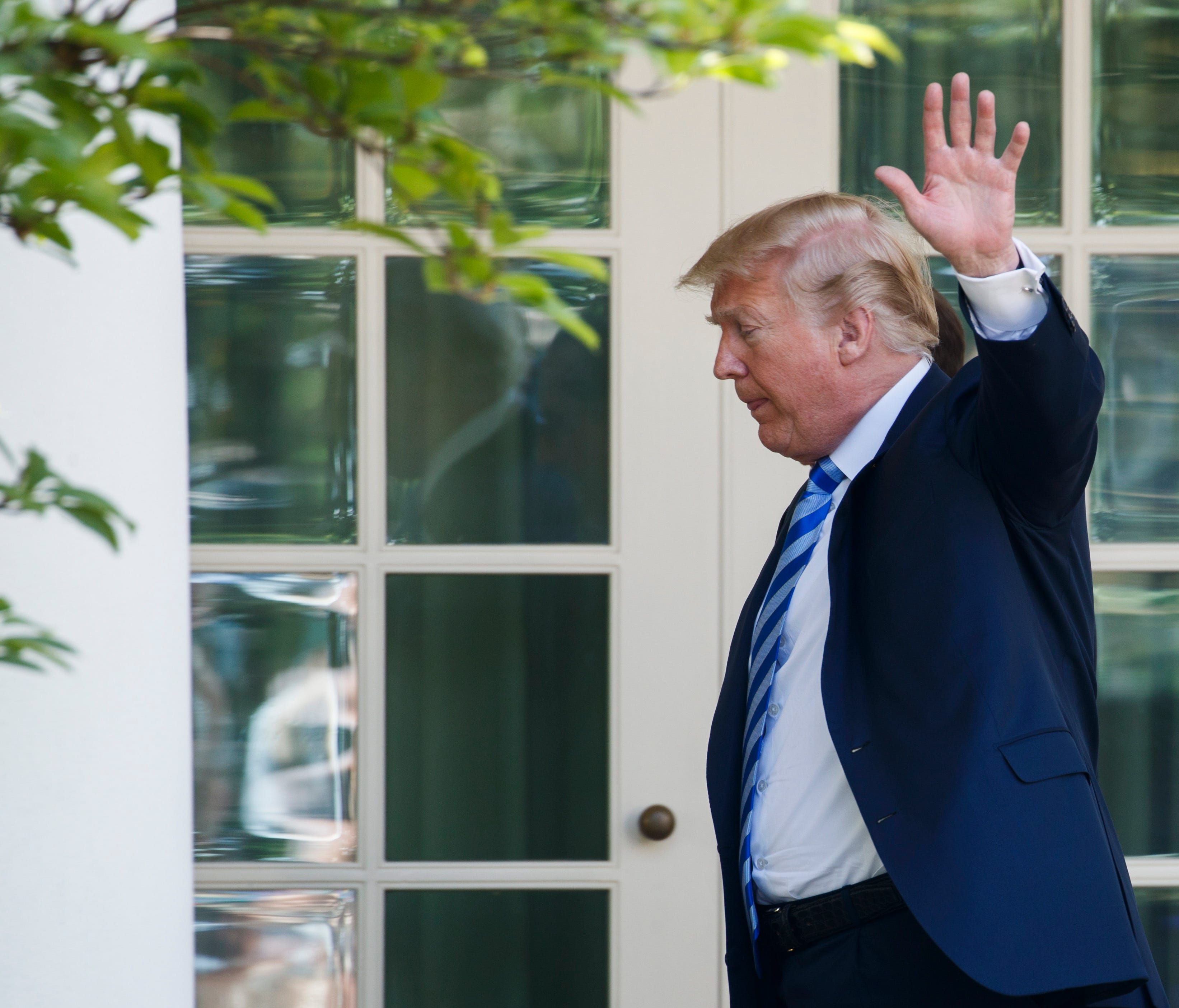 President Trump waves as he walks to the Oval Office after delivering remarks on lowering drug prices during an event in the Rose Garden of the White House Friday.