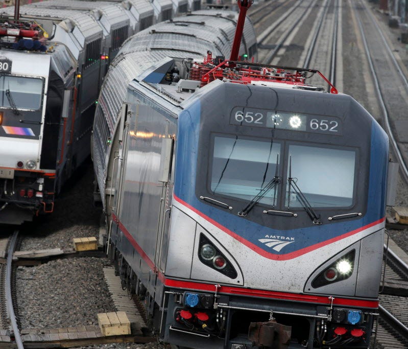 An Amtrak train passes a New Jersey Transit train stopped to discharge and board passengers at Elizabeth train station in Elizabeth, N.J., on March 12, 2016.