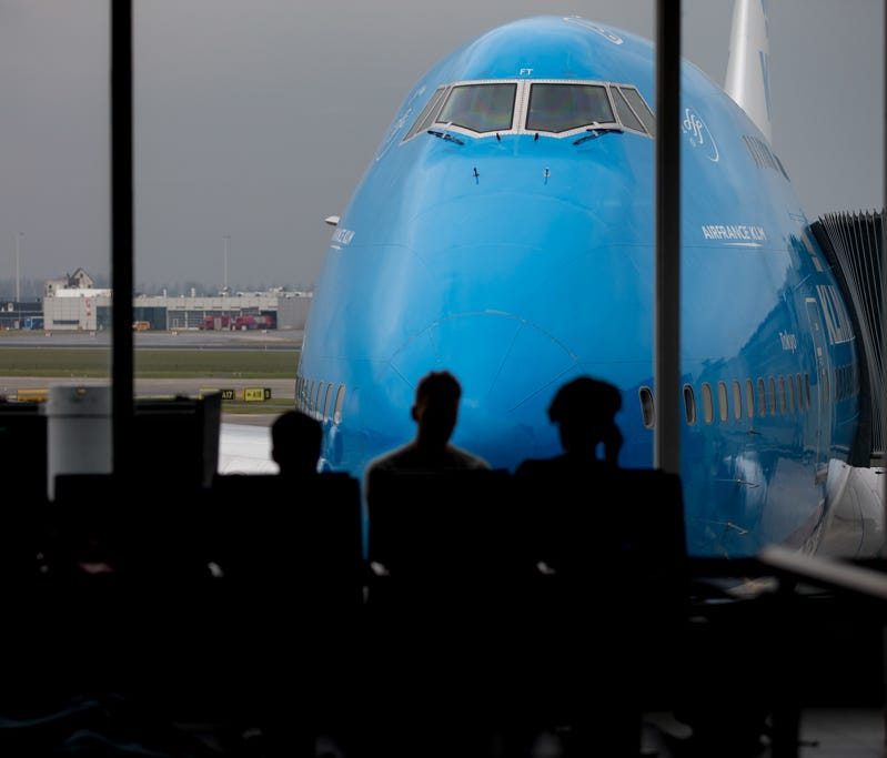 Passengers wait to board a KLM Boeing 747 at Amsterdam Schipol Airport on April 1, 2018.